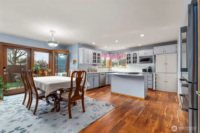 a kitchen with a table chairs refrigerator and wooden cabinets