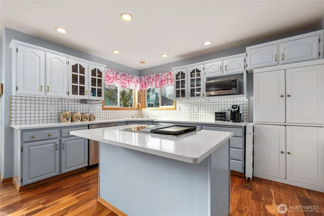a kitchen with kitchen island a sink stove and refrigerator