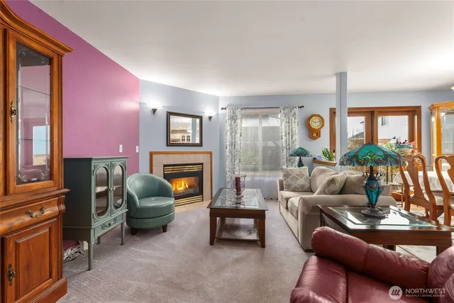 a living room with furniture a fireplace and a large window
