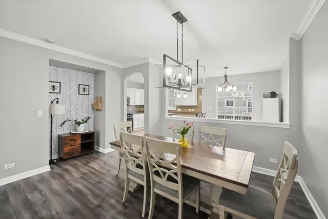 a view of a dining room with furniture a chandelier and wooden floor