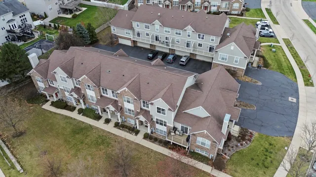 an aerial view of residential houses with outdoor space and parking
