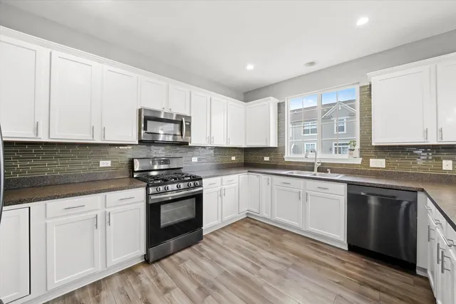 a kitchen with granite countertop white cabinets and appliances