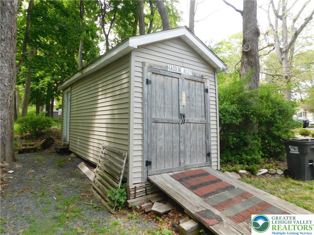 41 Reeder Street Mount Pocono, PA 18344 - Photo 37 of 41 A quaint storage shed offers convenient access with a ramp and double doors, nestled among natural landscaping.