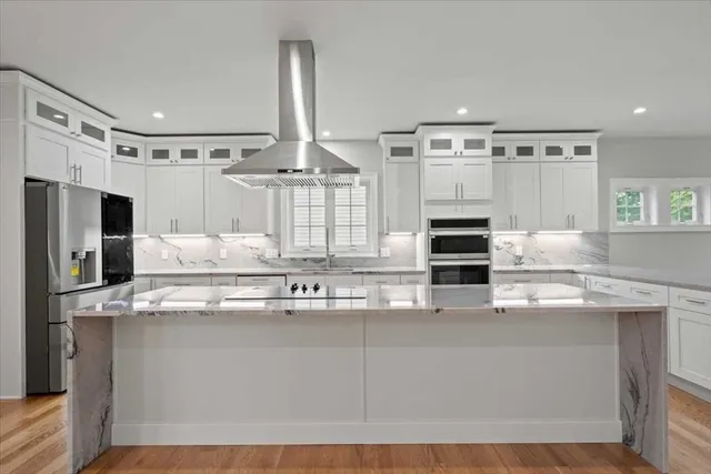 a kitchen with kitchen island granite countertop a sink stainless steel appliances and cabinets