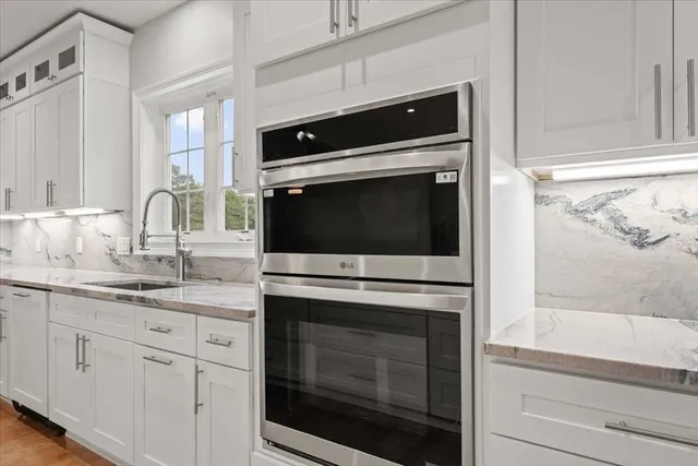a kitchen with granite countertop white cabinets stainless steel appliances and sink