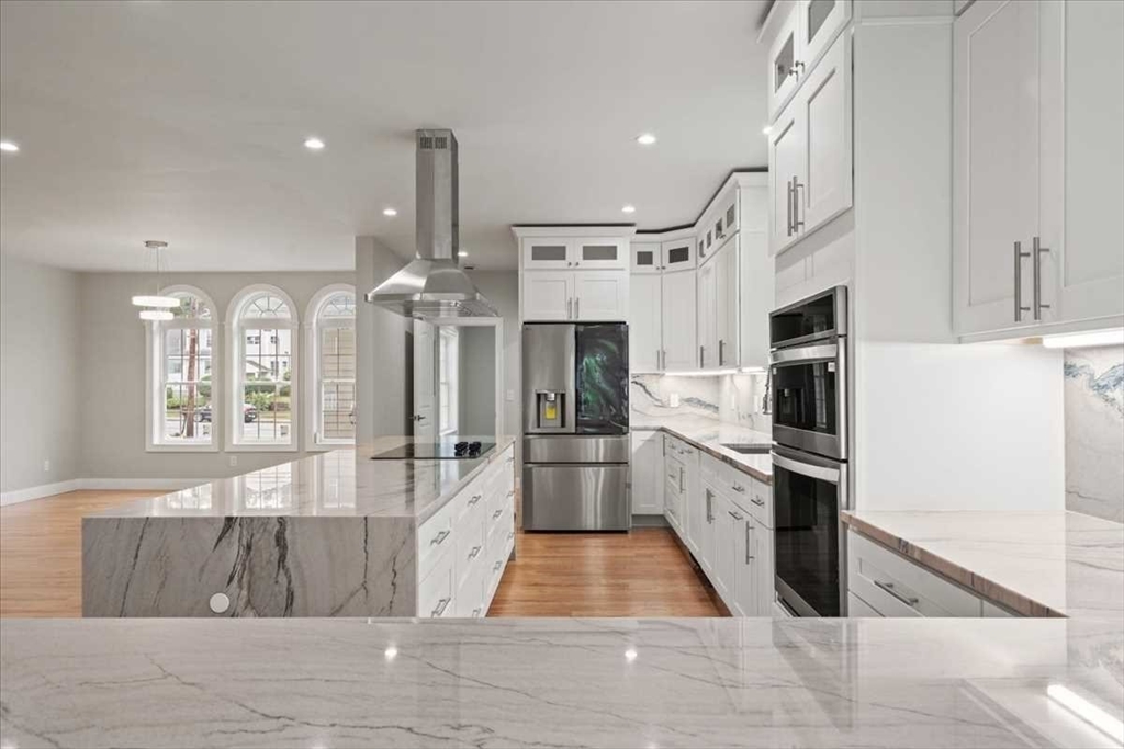 241 Lake Avenue Worcester, MA 01604 - Photo 15 of 42 a kitchen with stainless steel appliances kitchen island granite countertop a refrigerator oven a sink dishwasher and white cabinets with wooden floor