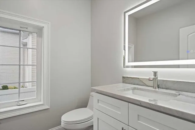 a bathroom with a granite countertop sink toilet a mirror and shower