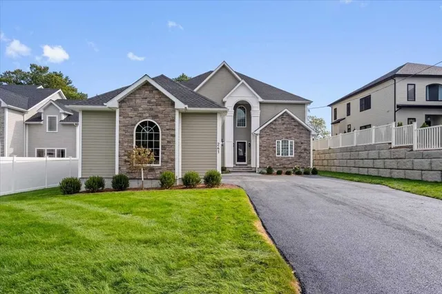 a view of a brick house with a big yard and large trees