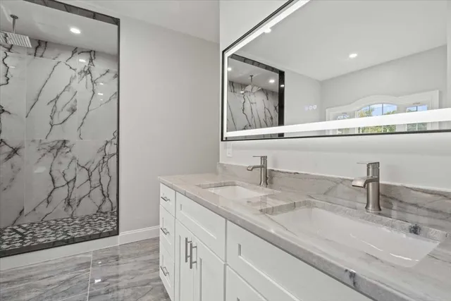 a bathroom with a granite countertop sink and a mirror