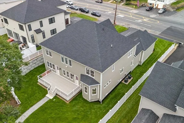 a aerial view of a house with a yard and a car parked