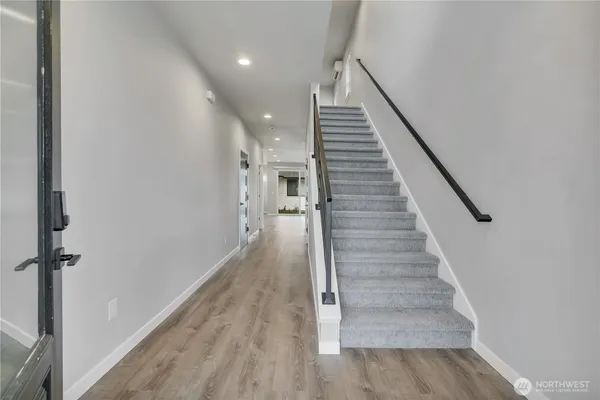 a view of entryway and hall with wooden floor