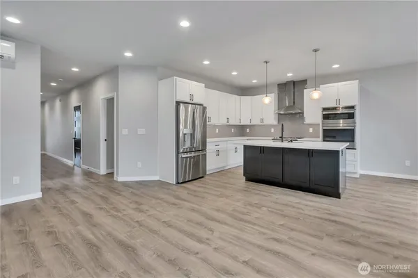 a large kitchen with stainless steel appliances kitchen island a large counter top and a refrigerator