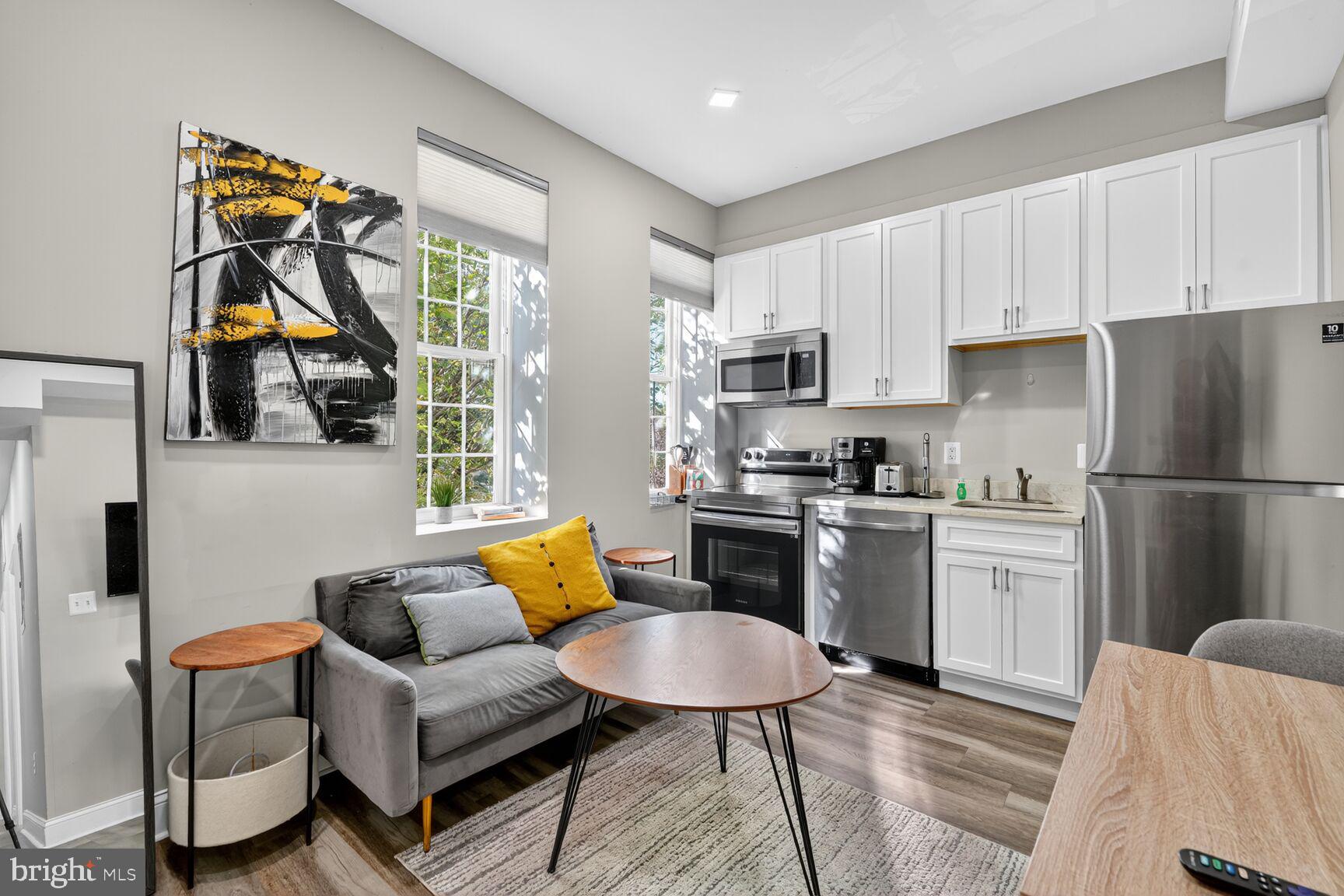 133 7th Street Southeast, Unit 1 Washington, DC 20003 - Photo 13 of 13 a kitchen with stainless steel appliances a refrigerator a stove a sink a dining table and chairs