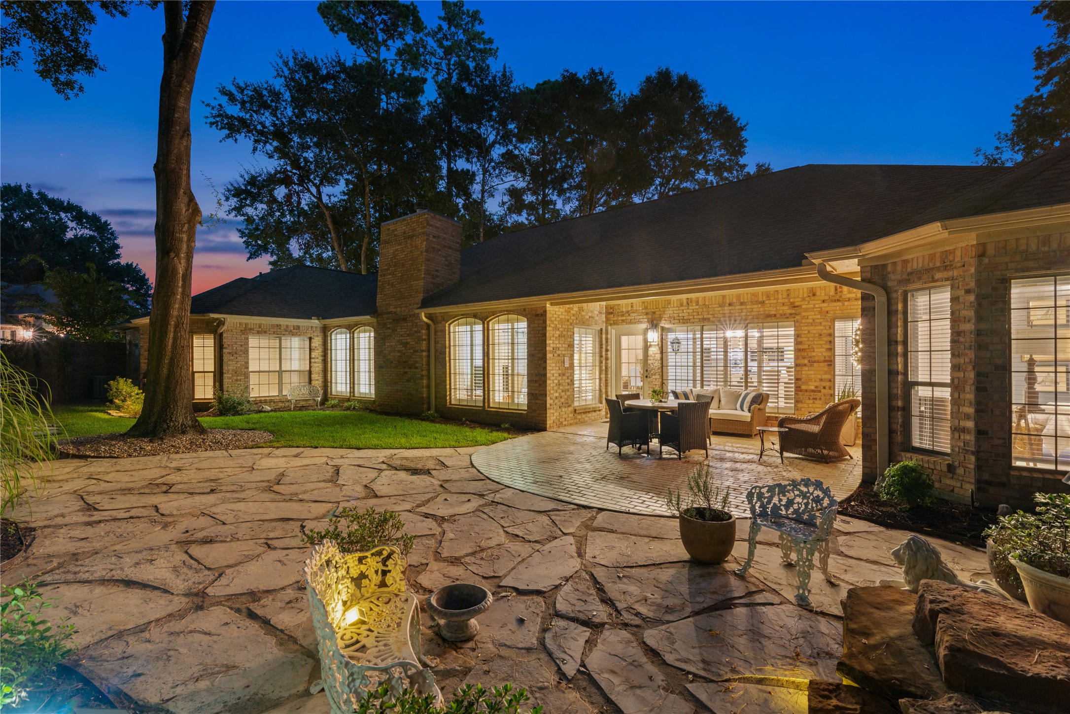 901 Longmire Road, Unit 51 Conroe, TX 77304 - Photo 44 of 48 Expansive stone patio, perfect for outdoor entertaining, featuring elegant lighting and lush surrounding greenery.