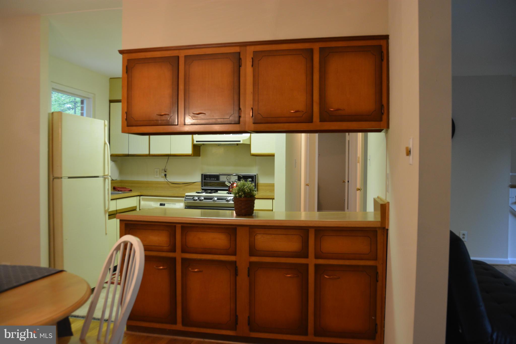 8702 Clydesdale Road Springfield, VA 22151 - Photo 8 of 17 a kitchen with stainless steel appliances granite countertop a refrigerator a sink dishwasher and cabinets with wooden floor