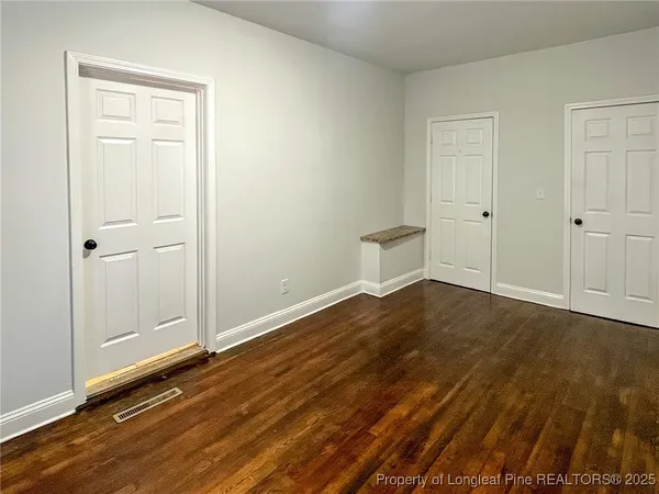 a view of a room with wooden floor and white doors