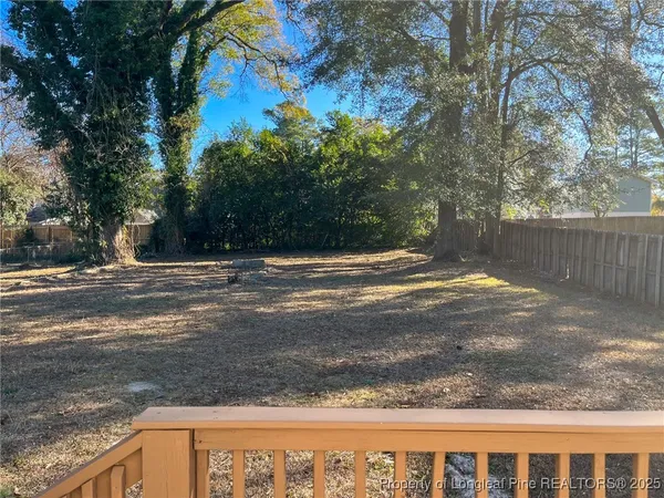 a view of a backyard with wooden fence