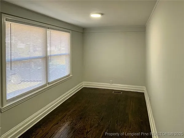 a view of a small space with wooden floor and a window