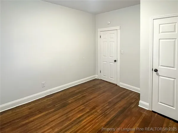 a view of a room with wooden floor and white walls