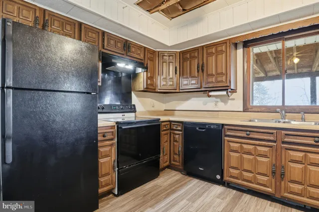 a kitchen with stainless steel appliances granite countertop a refrigerator and a stove top oven