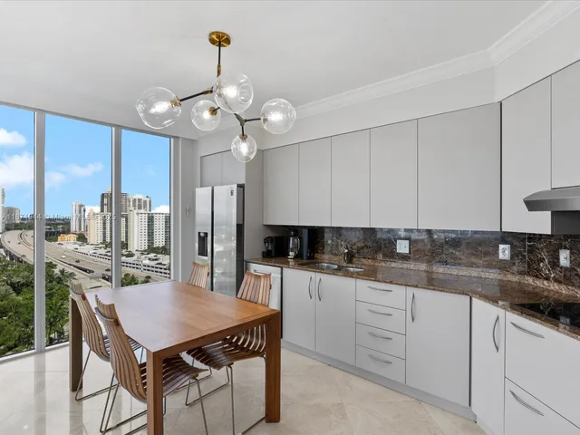 a kitchen with a kitchen island white cabinetry and stainless steel appliances