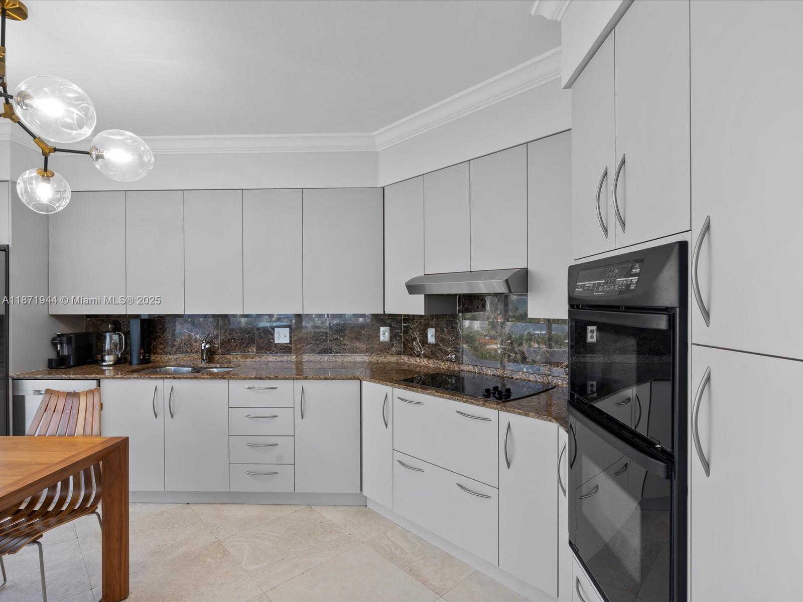 19111 Collins Avenue, Unit 1406 Sunny Isles Beach, FL 33160 - Photo 13 of 40 a kitchen with stainless steel appliances granite countertop a stove top oven a refrigerator a sink and dishwasher with white cabinets