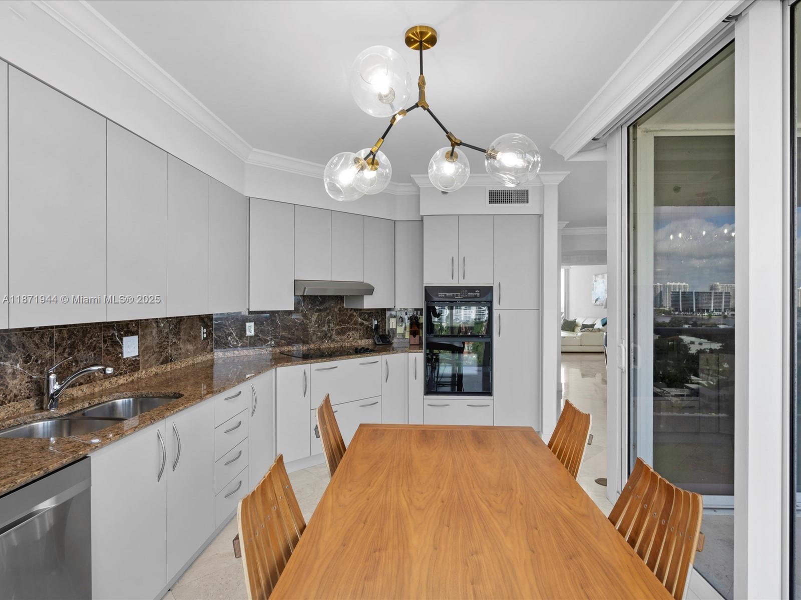 19111 Collins Avenue, Unit 1406 Sunny Isles Beach, FL 33160 - Photo 15 of 40 a kitchen with stainless steel appliances a refrigerator sink and cabinets