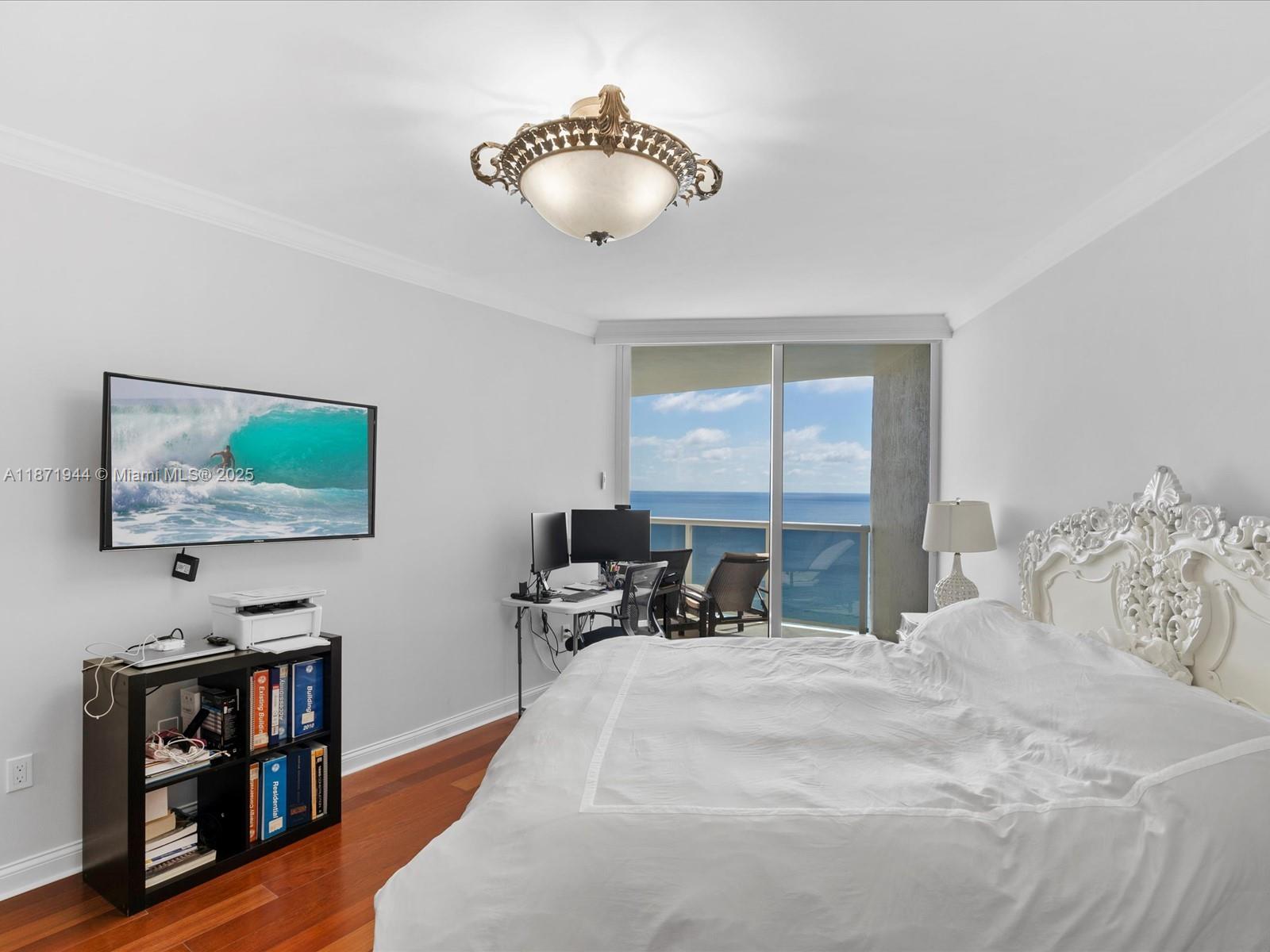 19111 Collins Avenue, Unit 1406 Sunny Isles Beach, FL 33160 - Photo 18 of 40 a bedroom with a bed and a flat screen tv