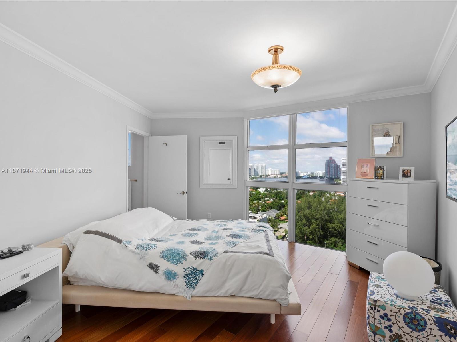 19111 Collins Avenue, Unit 1406 Sunny Isles Beach, FL 33160 - Photo 25 of 40 a bedroom with a bed and a chandelier