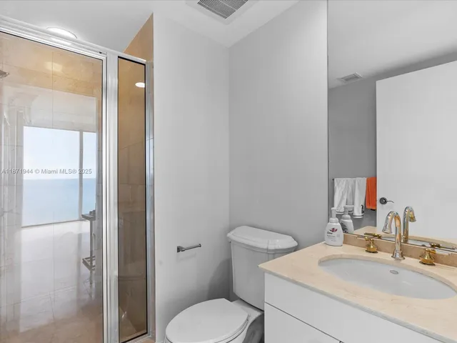 a bathroom with a toilet sink vanity and shower
