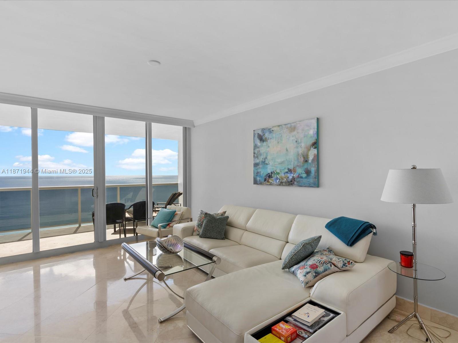 19111 Collins Avenue, Unit 1406 Sunny Isles Beach, FL 33160 - Photo 6 of 40 a living room with furniture and a large window with balcony view