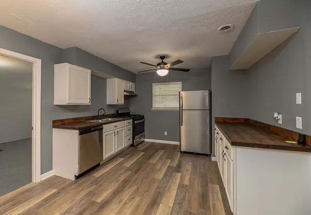 a kitchen with a refrigerator and a stove top oven
