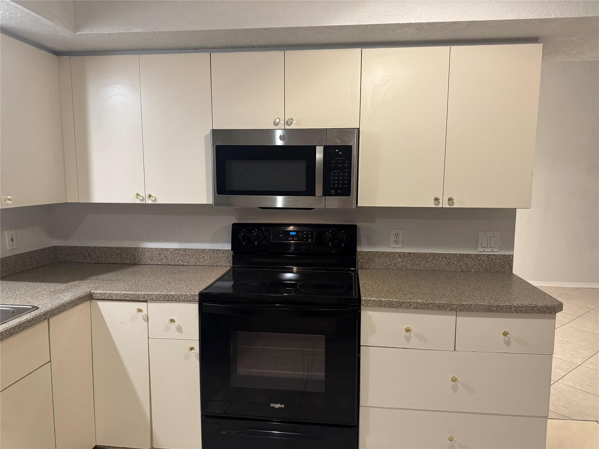 529 Guild Street Port Charlotte, FL 33954 - Photo 40 of 41 a kitchen with white cabinets and black appliances