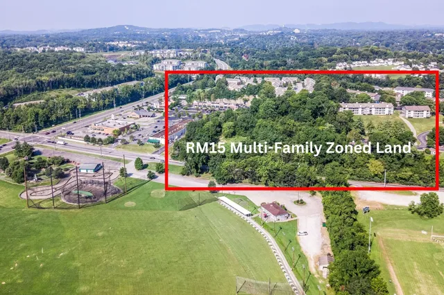 a view of a lush green field with some trees in the background