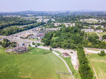 an aerial view of residential houses with outdoor space and trees
