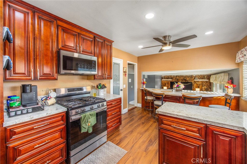 10399 Monte Vista Street Rancho Cucamonga, CA 91701 - Photo 13 of 43 a kitchen with stainless steel appliances a stove a sink dishwasher and cabinets with wooden floor