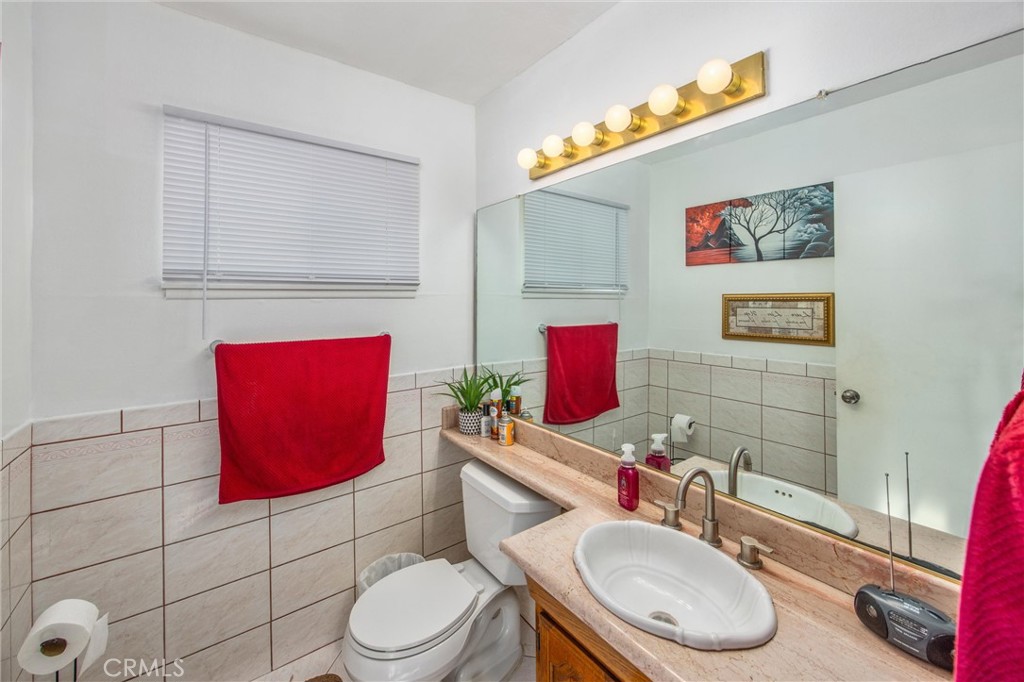 10399 Monte Vista Street Rancho Cucamonga, CA 91701 - Photo 25 of 43 a bathroom with a toilet sink vanity and mirror