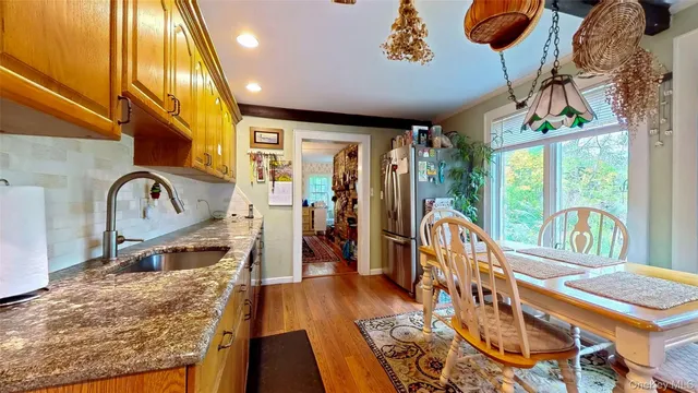 a living room with furniture pool table wooden floor and a large window