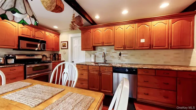 a kitchen with stainless steel appliances granite countertop a refrigerator a stove top oven a sink and dishwasher