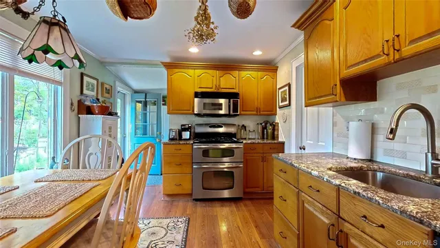 a kitchen with stainless steel appliances granite countertop a stove a sink and a microwave