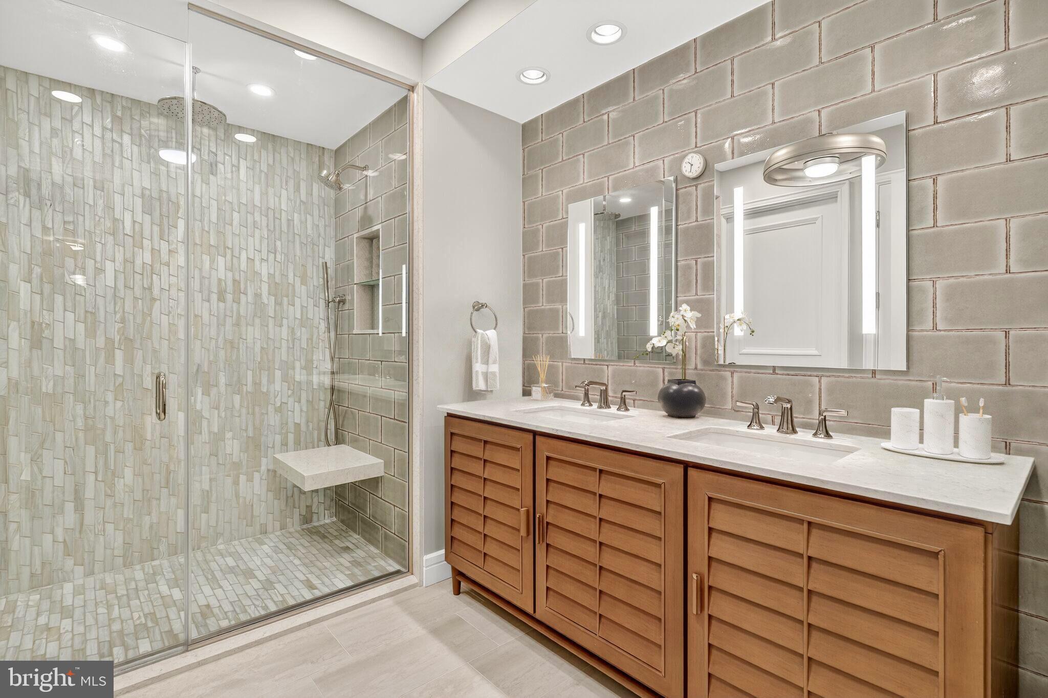 1155 23rd Street Northwest, Unit 3D Washington, DC 20037 - Photo 14 of 22 a bathroom with a double vanity sink mirror and shower