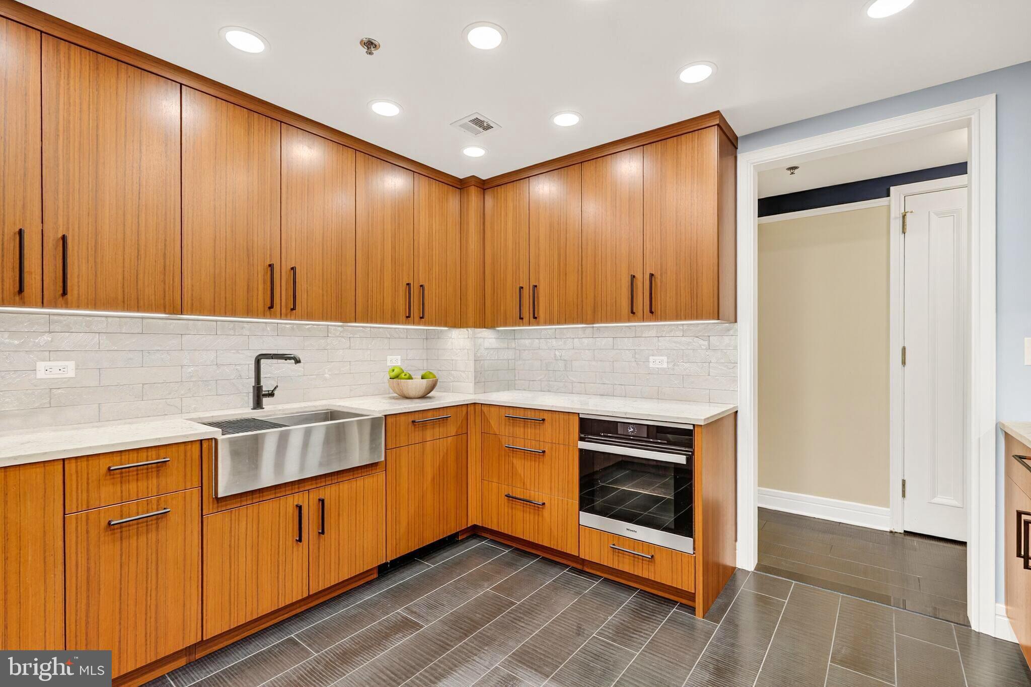 1155 23rd Street Northwest, Unit 3D Washington, DC 20037 - Photo 10 of 22 a kitchen with stainless steel appliances granite countertop wooden cabinets a sink and dishwasher