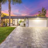 a front view of a house with a yard and potted plants