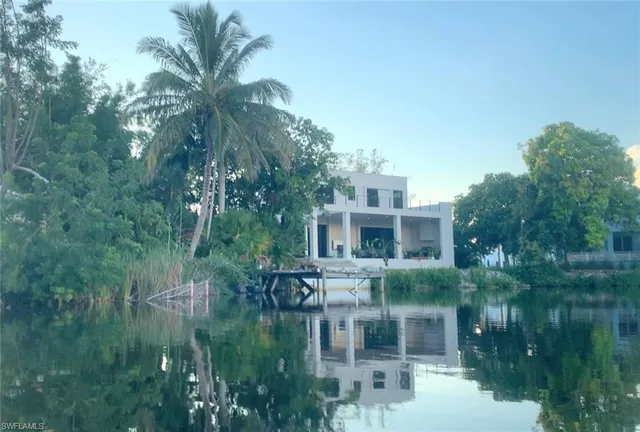 a front view of a house with a yard and lake view