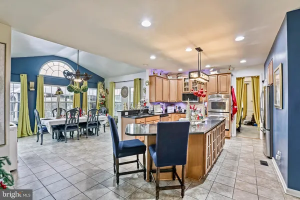 a living room with stainless steel appliances kitchen island granite countertop furniture and a kitchen view