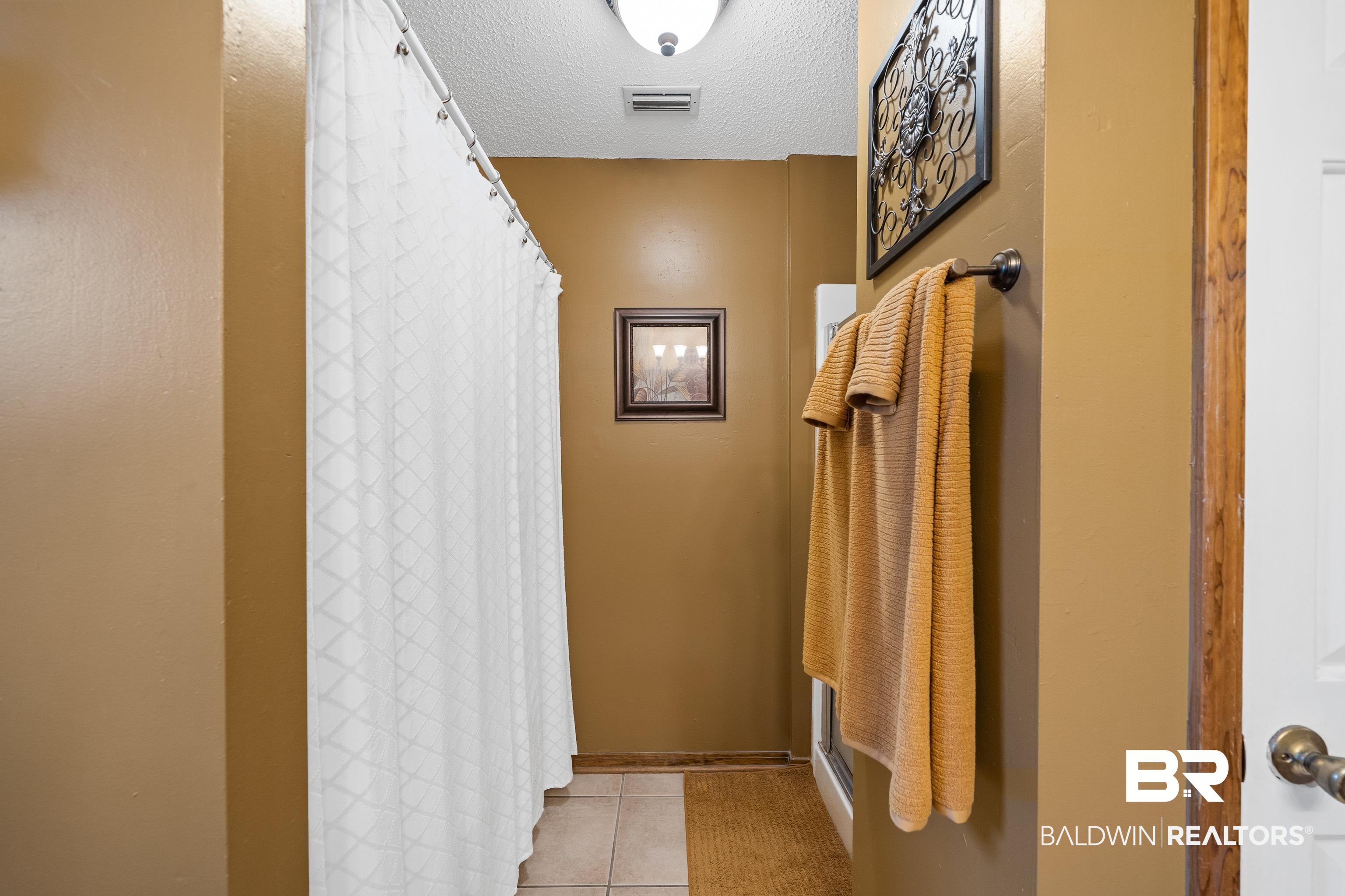 460 Ridgewood Drive Daphne, AL 36526 - Photo 21 of 31 Bathroom with a textured ceiling, tile patterned floors, and walk in shower
