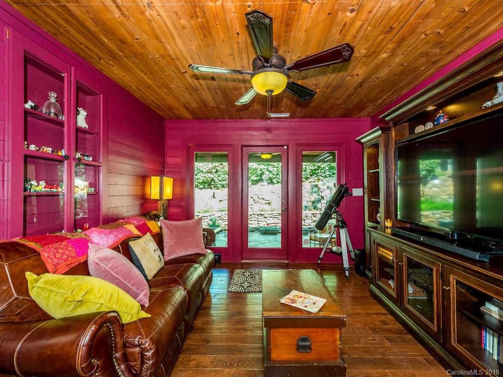 190 Euit Smith Road Tryon, NC 28782 - Photo 12 of 36 a living room with furniture a flat screen tv and a floor to ceiling window