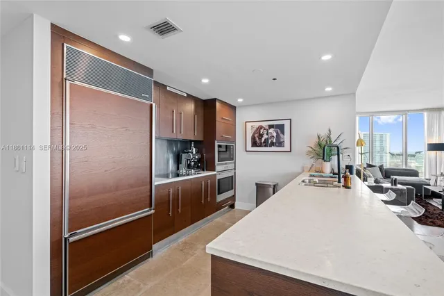 a kitchen with stainless steel appliances granite countertop a refrigerator and a sink
