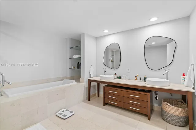 a bathroom with a double vanity sink mirror bathtub and a shower