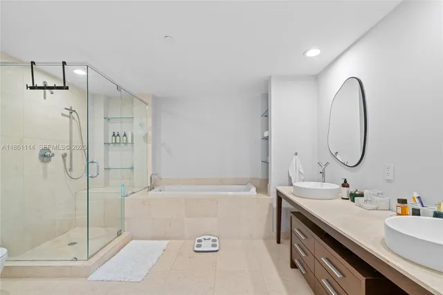 a bathroom with a tub sink mirror and shower